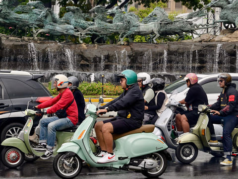 Vespa enthusiasts riding along a road in Jakarta.