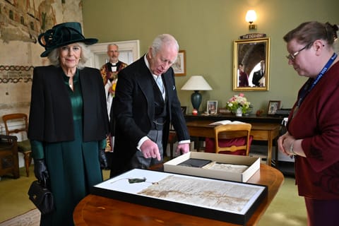 Britain's King Charles III and Britain's Queen Camilla look at a display of the Cathedral’s Magna Cartas after attending the Royal Maundy Service at Durham Cathedral on April 17, 2025 in Durham, England.