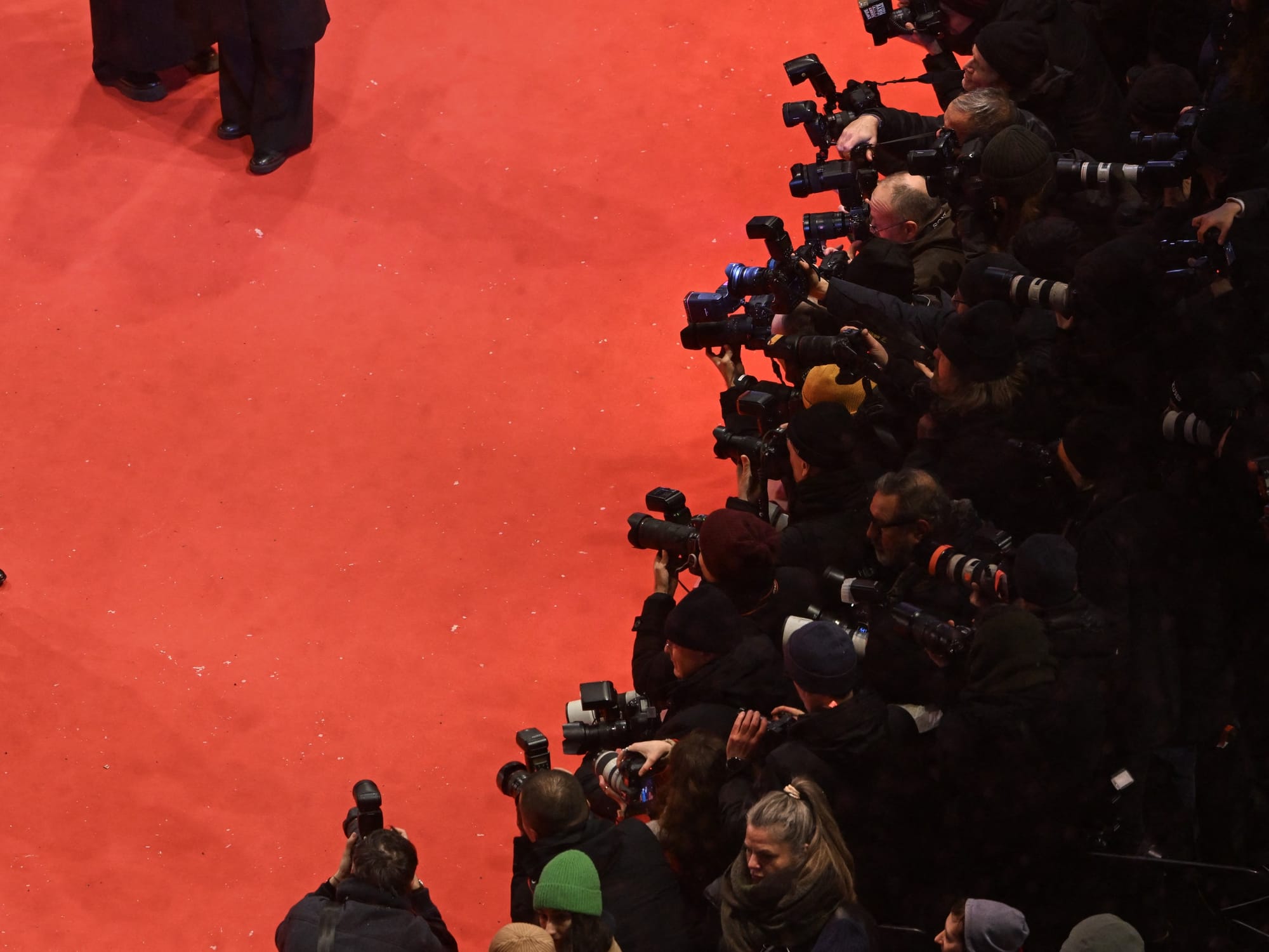 An illustrative image of the press gathered on a red carpet to capture images
