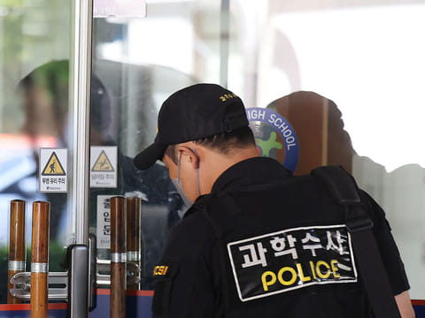 Members of South Korean Police Crime Scene Investigation team probe at a high school in Cheongju after a knife attack by a student.