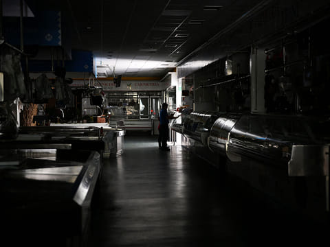 A man and a child walk through a local market during a massive power cut in Vigo, northwestern Spain, on April 28, 2025.  