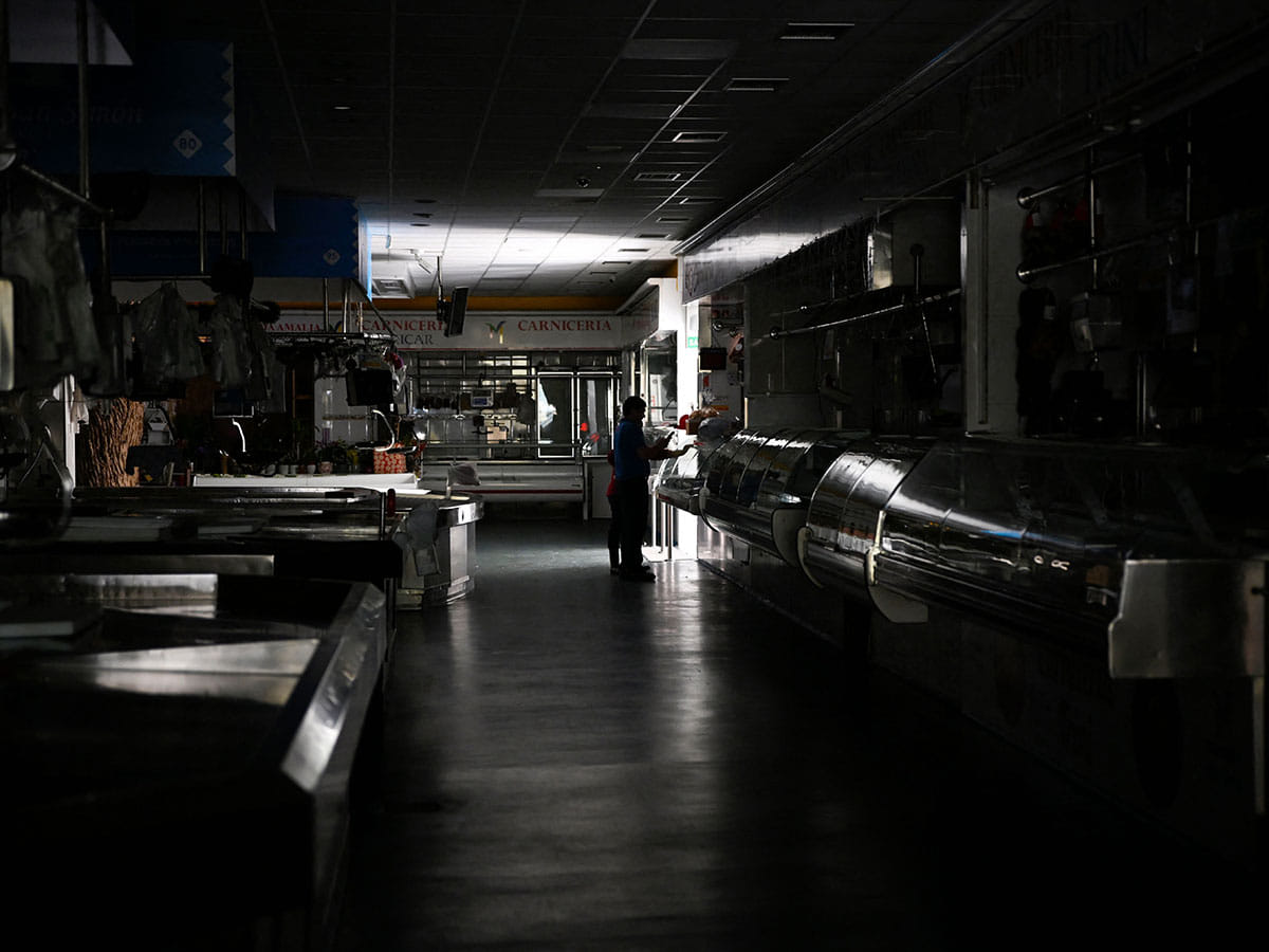 A man and a child walk through a local market during a massive power cut in Vigo, northwestern Spain, on April 28, 2025.  