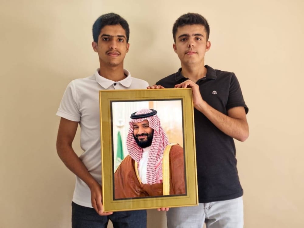 Yaqoub Al Manjam (left) and Turkish Ali hold a portrait of Saudi Crown Prince Mohammed bin Salman. 