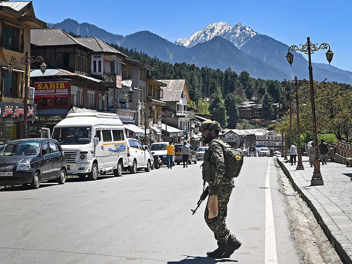 An Indian paramilitary trooper patrols at a market area in Pahalgam south of Srinagar on April 29, 2025. 