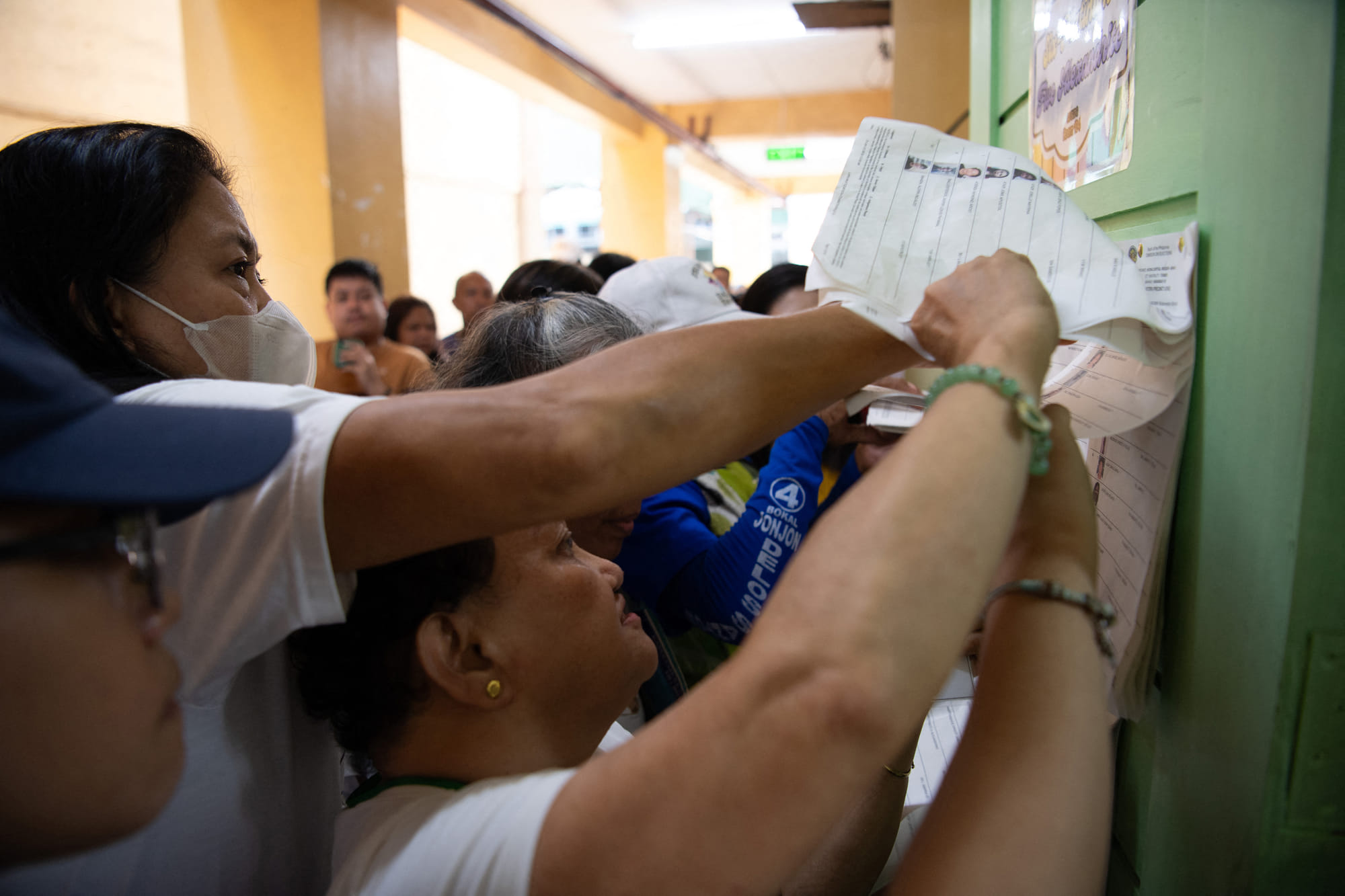 Voters jostle with one another as they look for their names in a registration list for the mid-term election at a polling station in Manila on May 12, 2025.