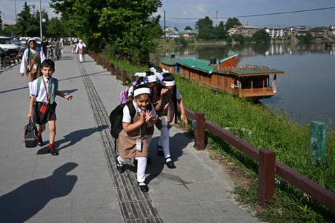Students walk to attend classes as their school reopened after a ceasefire between Pakistan and India, in Srinagar on May 13, 2025. 