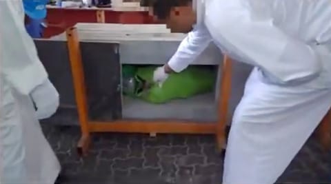 A customs official examines hashish that had been secretly hidden inside marble slabs in a shipment arriving at Kuwait's Shuwaikh Port earlier this month.