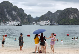 This picture taken on May 24, 2025, shows tourists enjoying the beach on an island in Ha Long bay in Vietnam's Quang Ninh province.