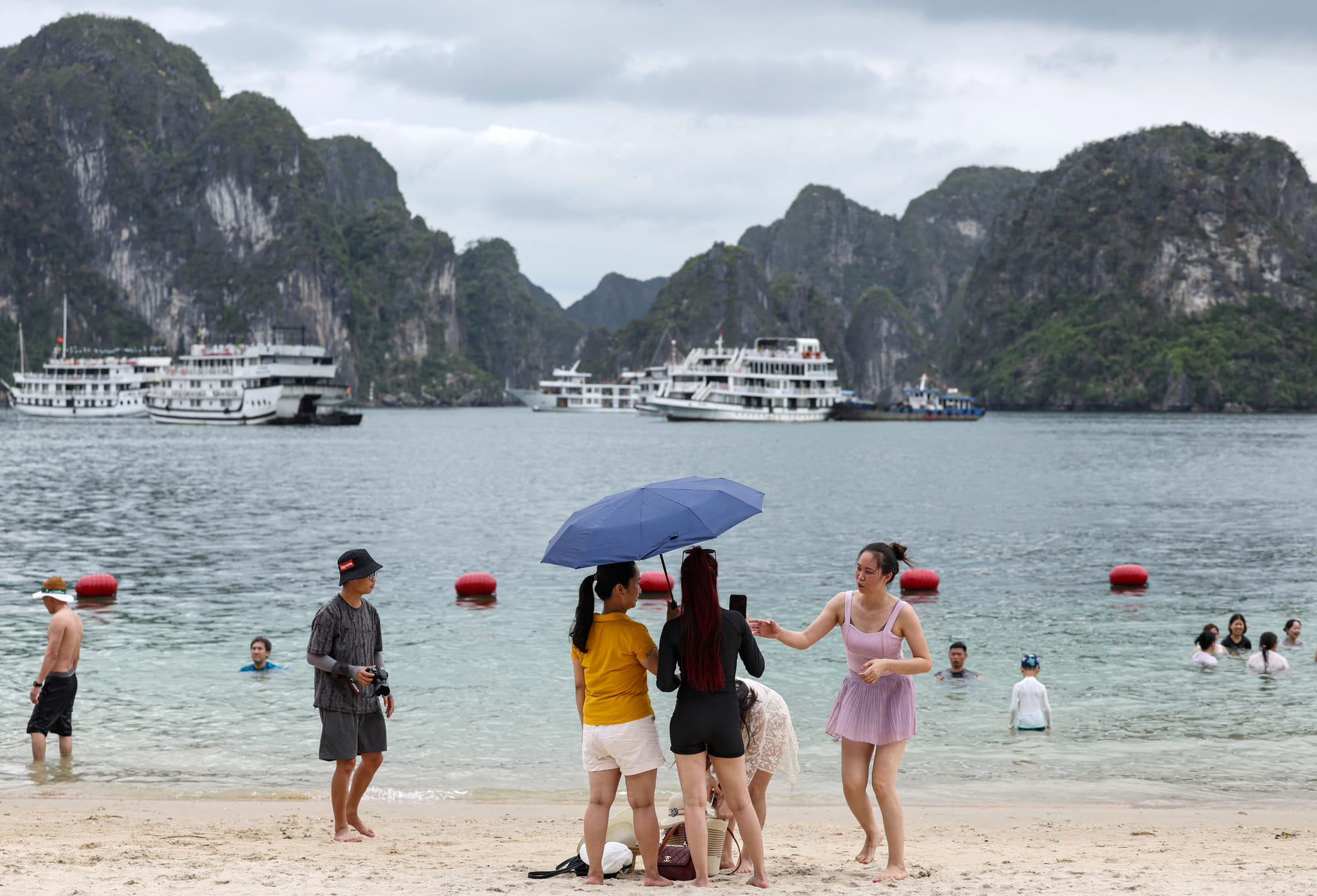 This picture taken on May 24, 2025, shows tourists enjoying the beach on an island in Ha Long bay in Vietnam's Quang Ninh province.