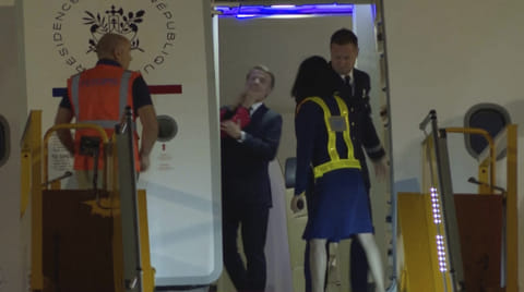 In this grab taken from video, a hand shoves France's President Emmanuel Macron's face away as he prepares to disembark a plane on arrival, in Hanoi, Vietnam, Sunday, May 25, 2025.