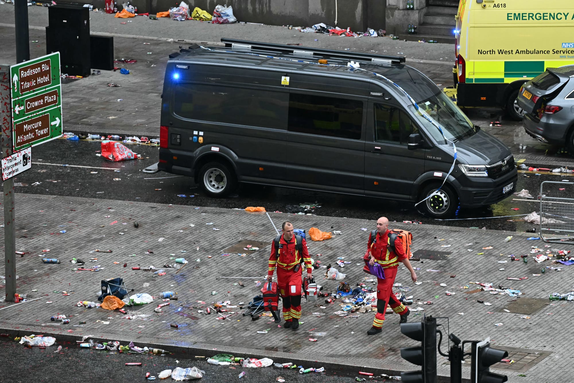 Members of the emergency services are pictured on the scene of the crash in Water Street, on the sidelines of an open-top bus victory parade for Liverpool's Premier League title win on Monday..