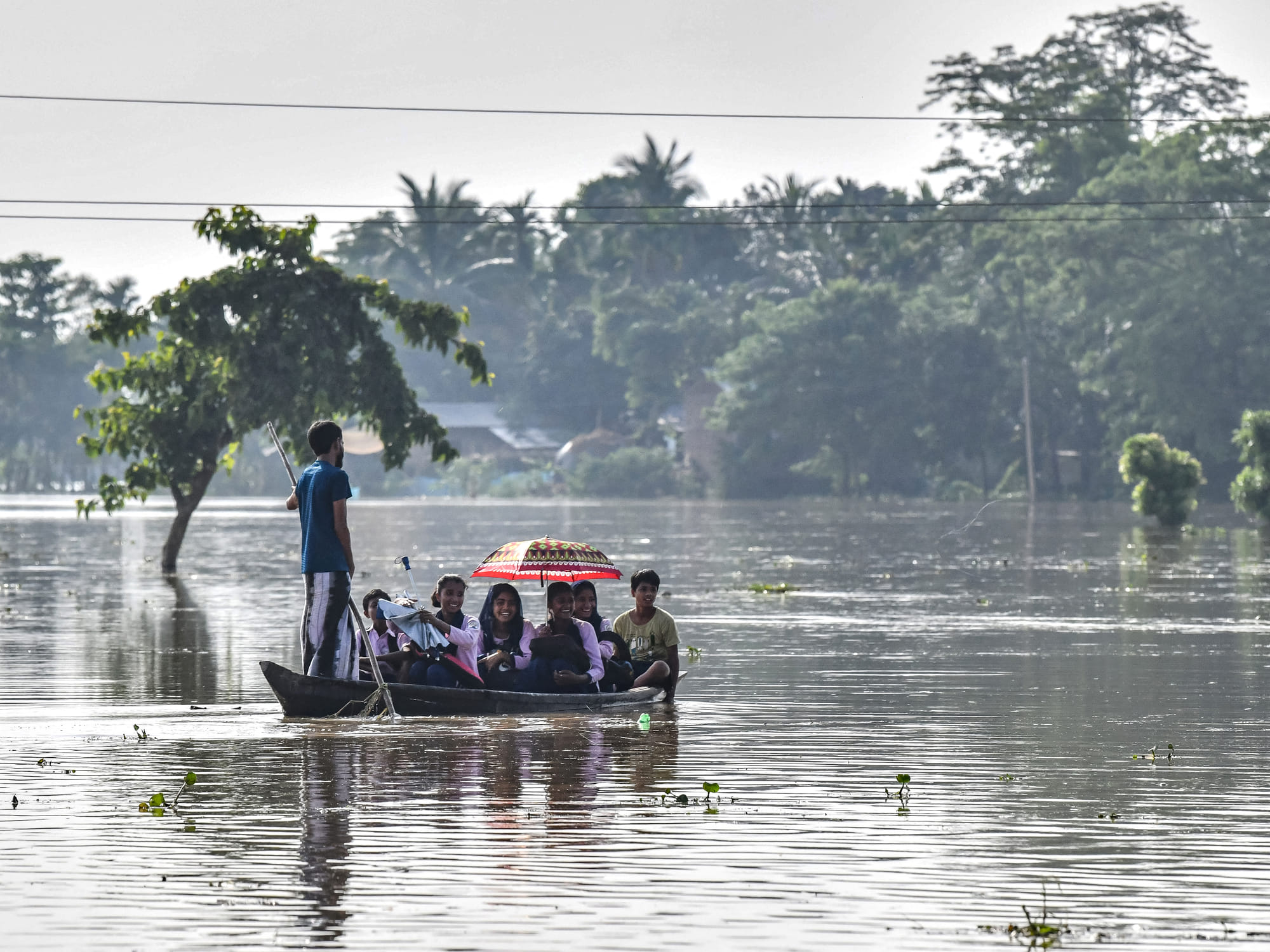 School children return home on a boat after heavy rains at a flood affected area in Kampur at Nagaon district, in India's northeastern state of Assam.