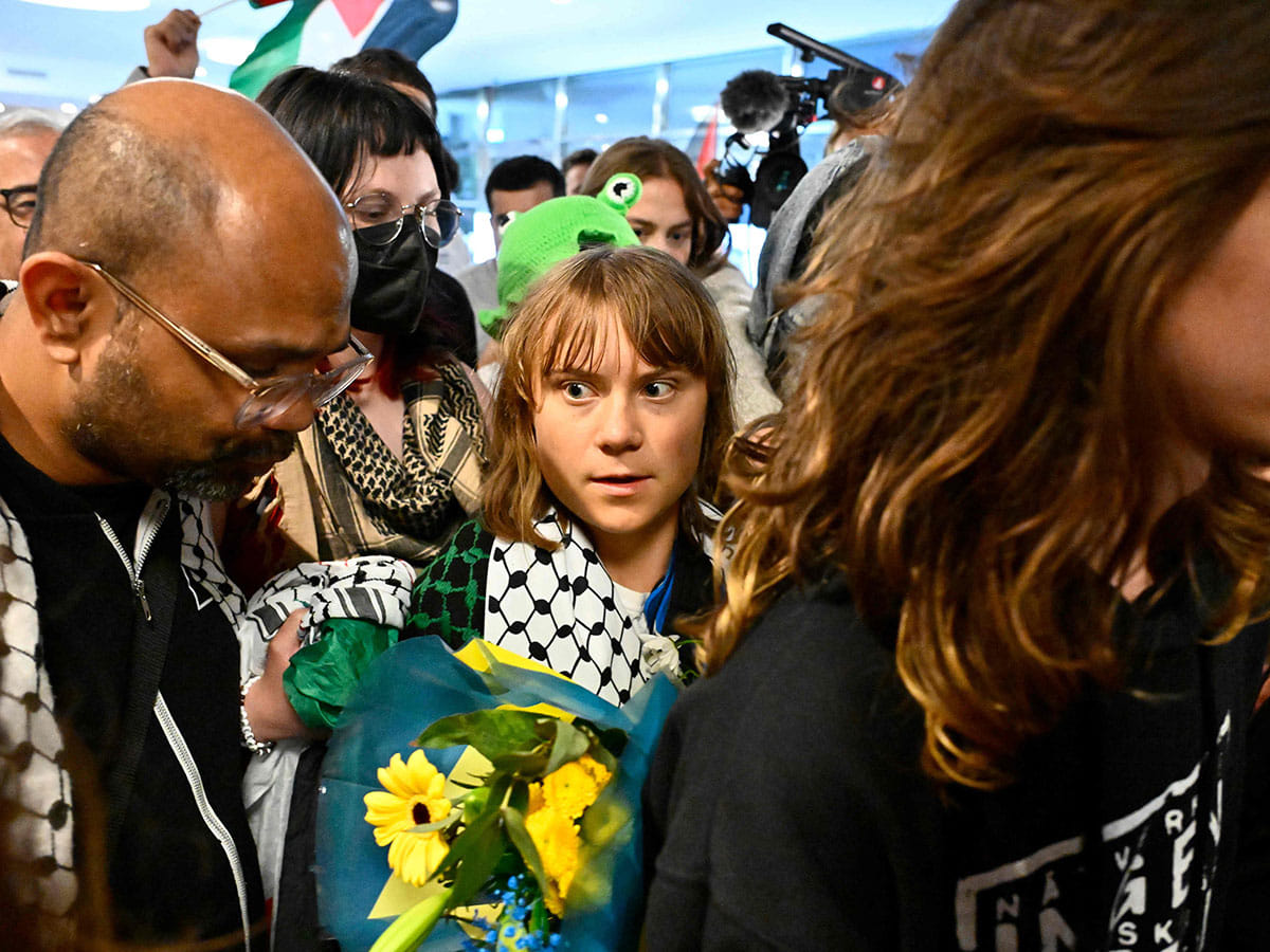 Swedish campaigner Greta Thunberg (C) looks on as she is greeted on arrival at Stockholm-Arlanda airport, on the outskirts of Stockholm.