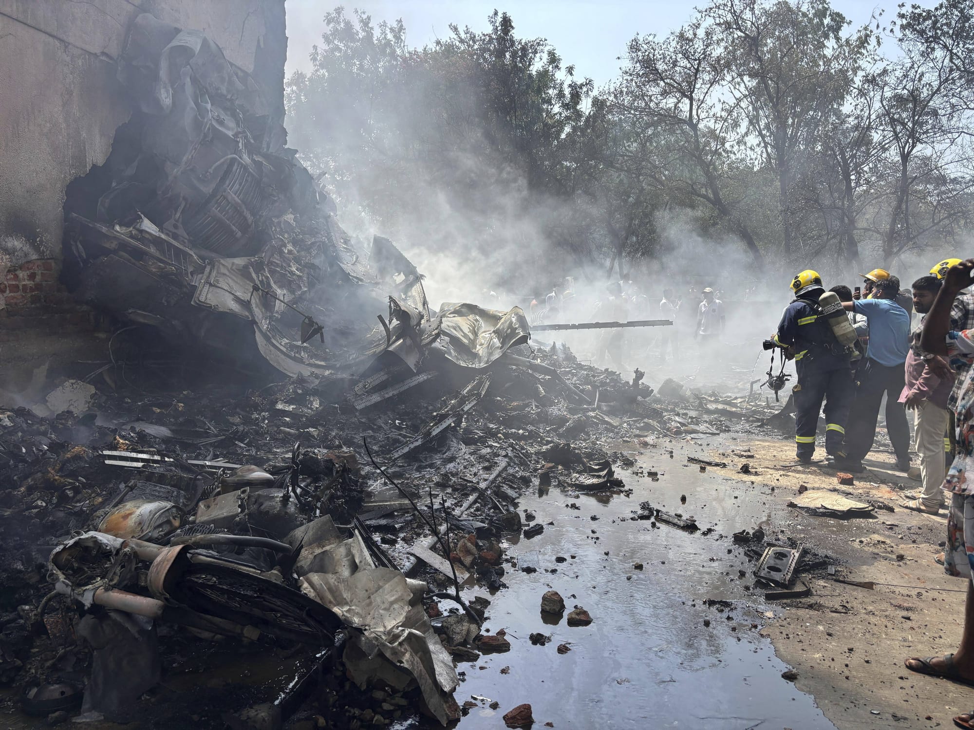 Firefighters work at the site where an Air India airplane crashed in Ahmedabad.