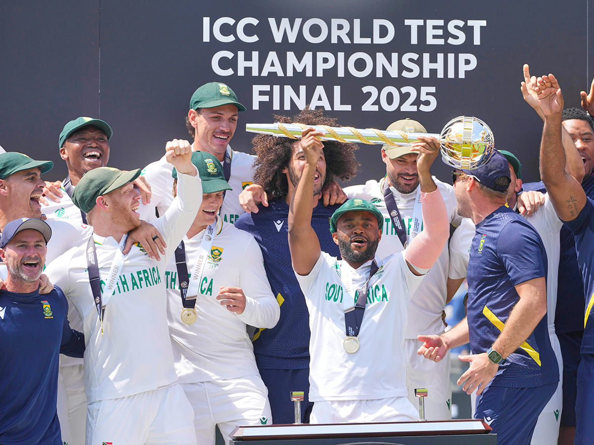 South Africa's captain Temba Bavuma holds the winner's trophy and celebrates with teammates on the podium after their win in the World Test Championship against Australia at Lord's cricket ground in London, on Saturday, June 14, 2025. 