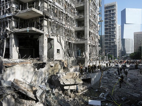 Rescue workers and military personnel inspect the site of a direct hit from an Iranian missile strike in Ramat Gan, Israel, Thursday, June 19, 2025. 