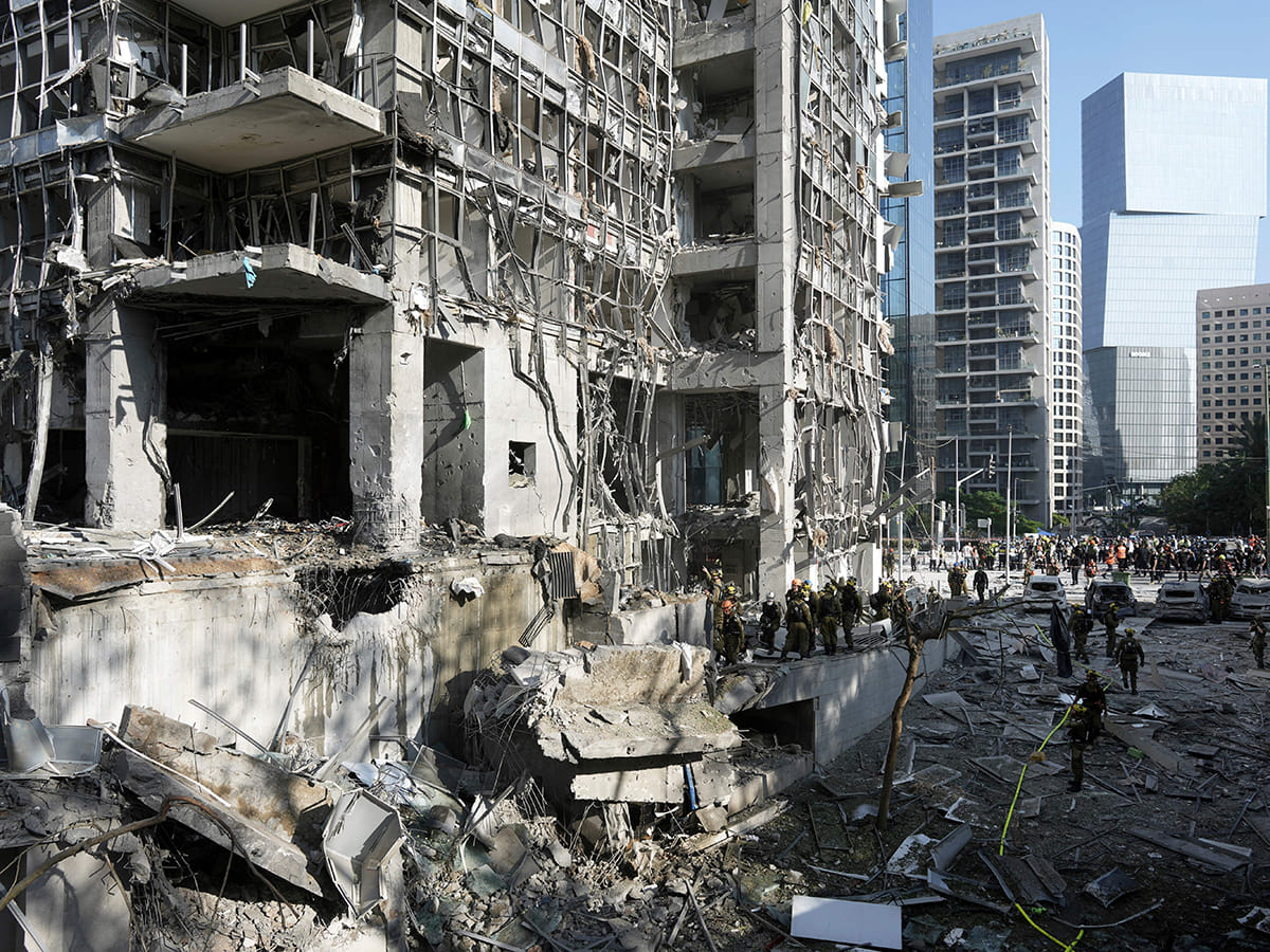 Rescue workers and military personnel inspect the site of a direct hit from an Iranian missile strike in Ramat Gan, Israel, Thursday, June 19, 2025. 
