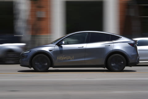 A driverless Tesla robotaxi, a ride-booking service, moves through traffic, Sunday, June 22, 2025, in US.