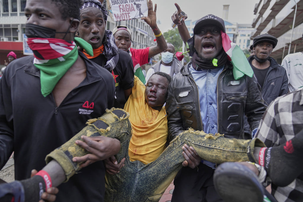 A man is carried by protesters after being beaten by anti riot police during a demonstration in downtown Nairobi, Kenya, Wednesday, June 25, 2025. 