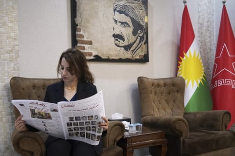 Kawsar Fattahi, a member of the central committee of the Komala Party of Iranian Kurdistan, reads the party's newspaper, Asoy Rojhelat, at one of its offices in an undisclosed location in Iraq's Irbil governorate, June 19, 2025. (AP Photo/Rashid Yahya)