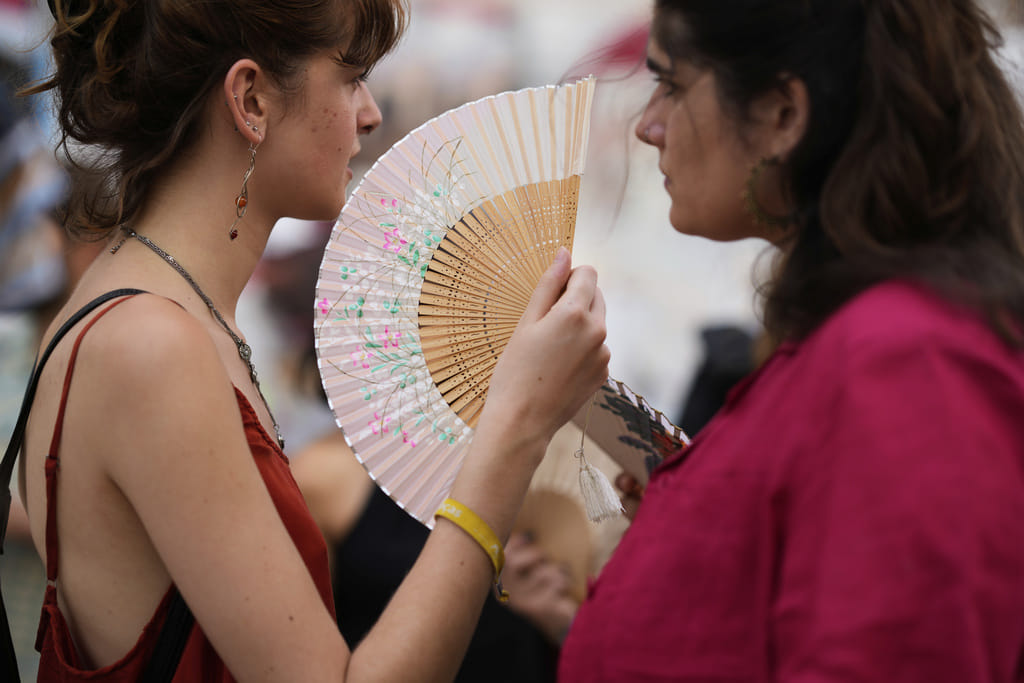 Demonstrators use fans to help with the high temperature during a protest against the housing crisis affecting Portugal, in Lisbon, Saturday, June 28, 2025. 
