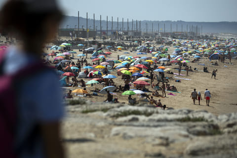 This picture shows people on Costa da Caparica beach in Almada, near Lisbon, during the first heatwave of the year, on June 29, 2025.