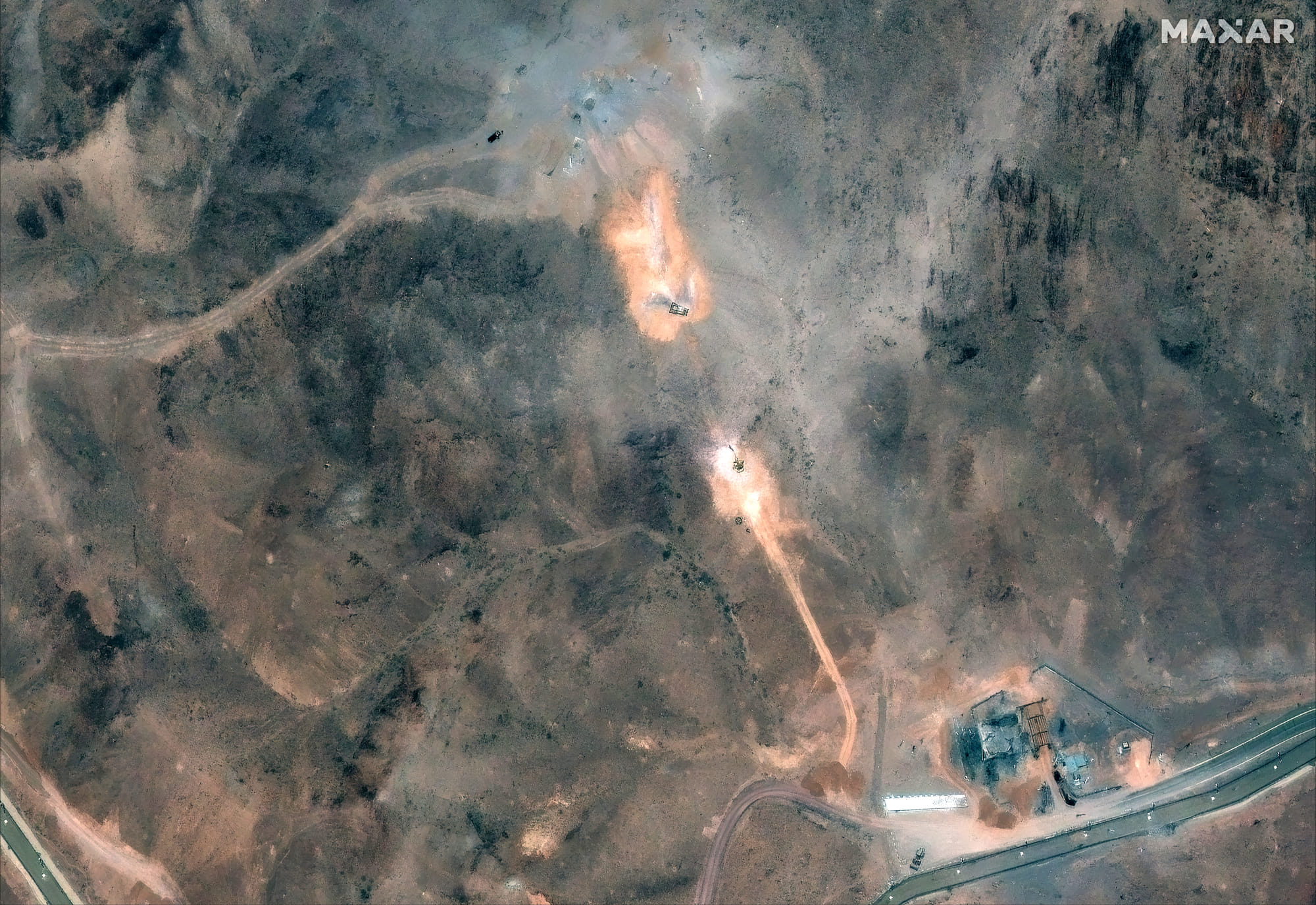This handout satellite image provided by Maxar Technologies and dated July 1, 2025, shows activity near the perimeter building and southern holes caused by the June 22 US airstrike on the Fordo (Fordow) Fuel Enrichment Plant complex, about 30 kilometres north of Qom in central Iran.