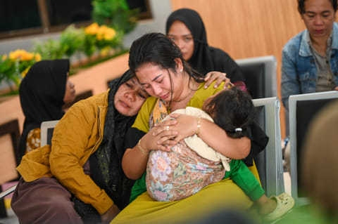 Family members and relatives wait for updates on the search operation of at least 61 people who were missing after a ferry sank off the popular Indonesian resort island of Bali, at Ketapang Port in Banyuwangi, East Java on July 3, 2025.