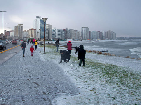 People play with snow on a beach in Miramar, Buenos Aires Province, Argentina, on June 30, 2025.