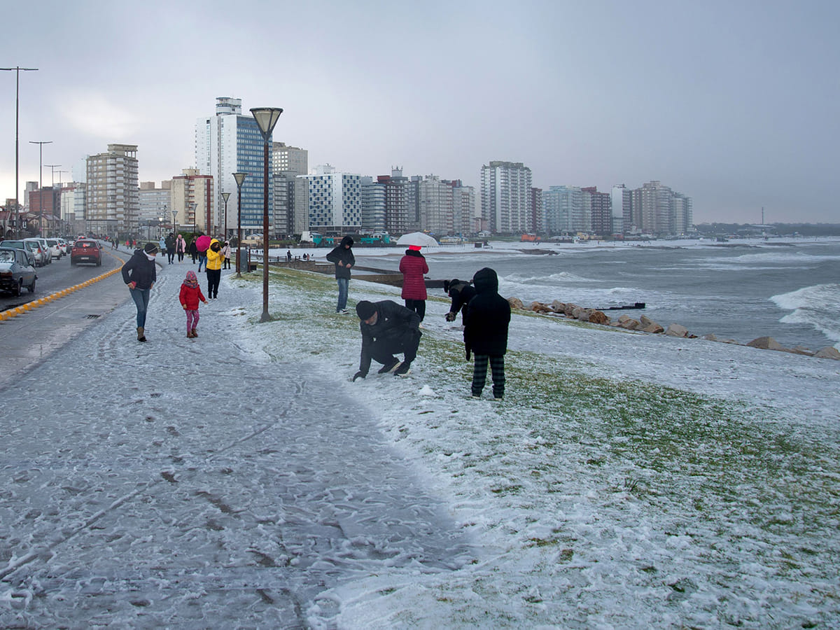 People play with snow on a beach in Miramar, Buenos Aires Province, Argentina, on June 30, 2025.