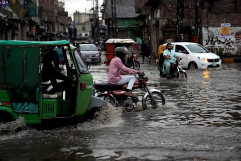 Motorists drive through a flooded road caused by heavy monsoon rains, in Lahore, Pakistan, Sunday, June 29, 2025. 