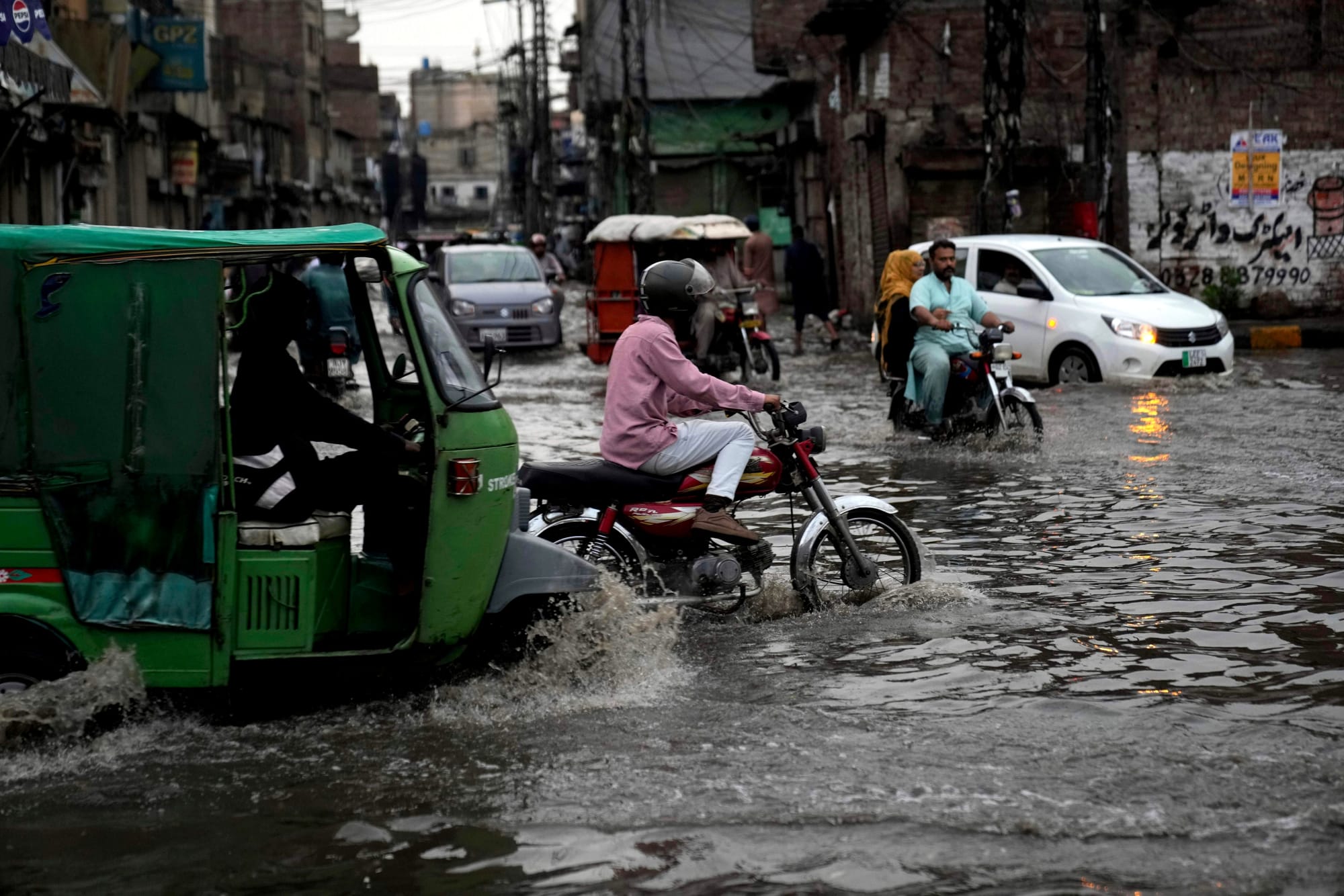 Motorists drive through a flooded road caused by heavy monsoon rains, in Lahore, Pakistan, Sunday, June 29, 2025. 