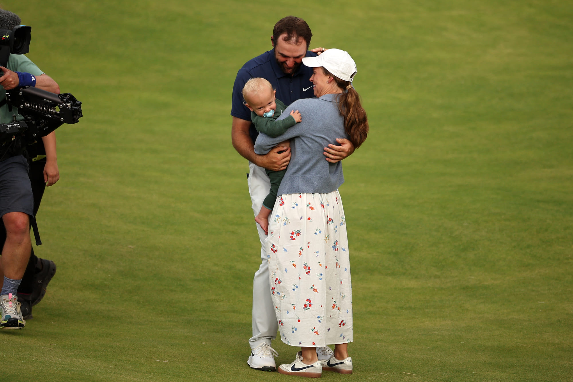 US golfer Scottie Scheffler celebrates with his wife Meredith and son Bennett on the 18th green after his victory in the 153rd Open Championship at Royal Portrush golf club in Northern Ireland on July 20, 2025.