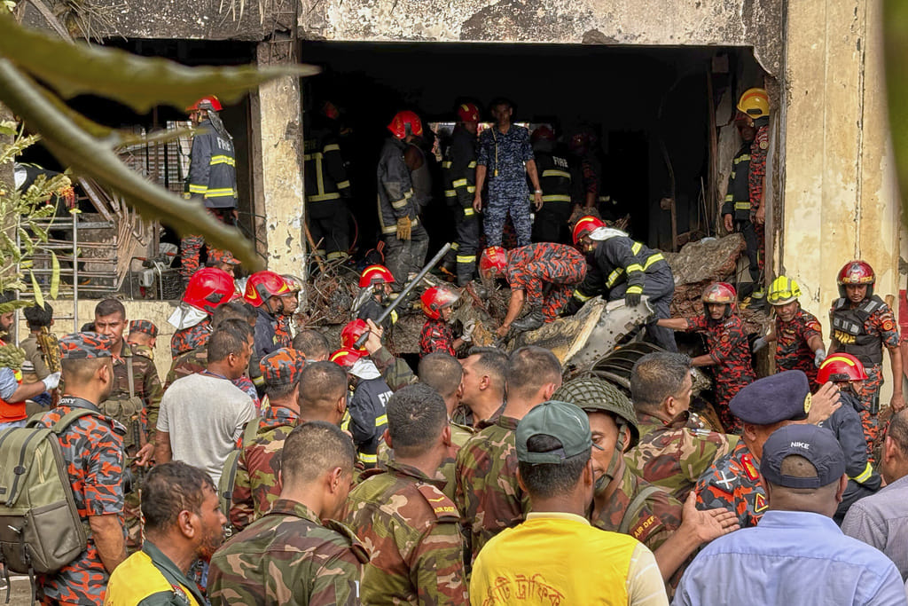 Firemen check the wreckage of a Bangladesh Air Force training aircraft that crashed onto a school campus in Dhaka, Bangladesh, Monday, July 21, 2025. 
