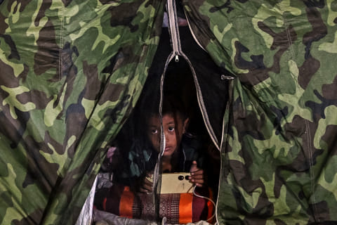 A boy displaced by the ongoing conflict between Thailand and Cambodia rests at an evacuation center in the Thai border province of Si Sa Ket on July 26, 2025.