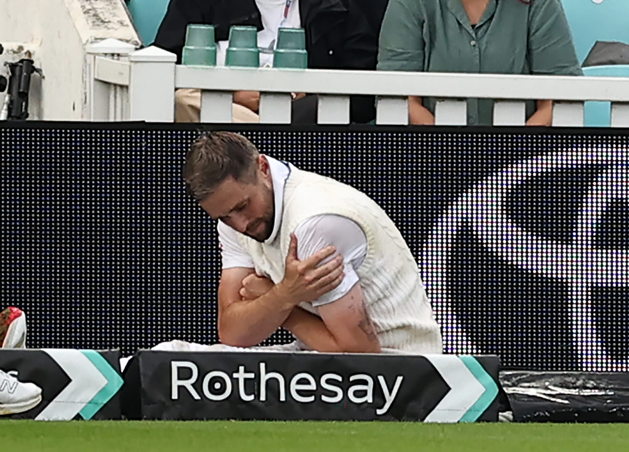 England's Chris Woakes holds his shoulder after falling over at the boundary on the first day of the fifth Test against India at The Oval in London on Thursday.