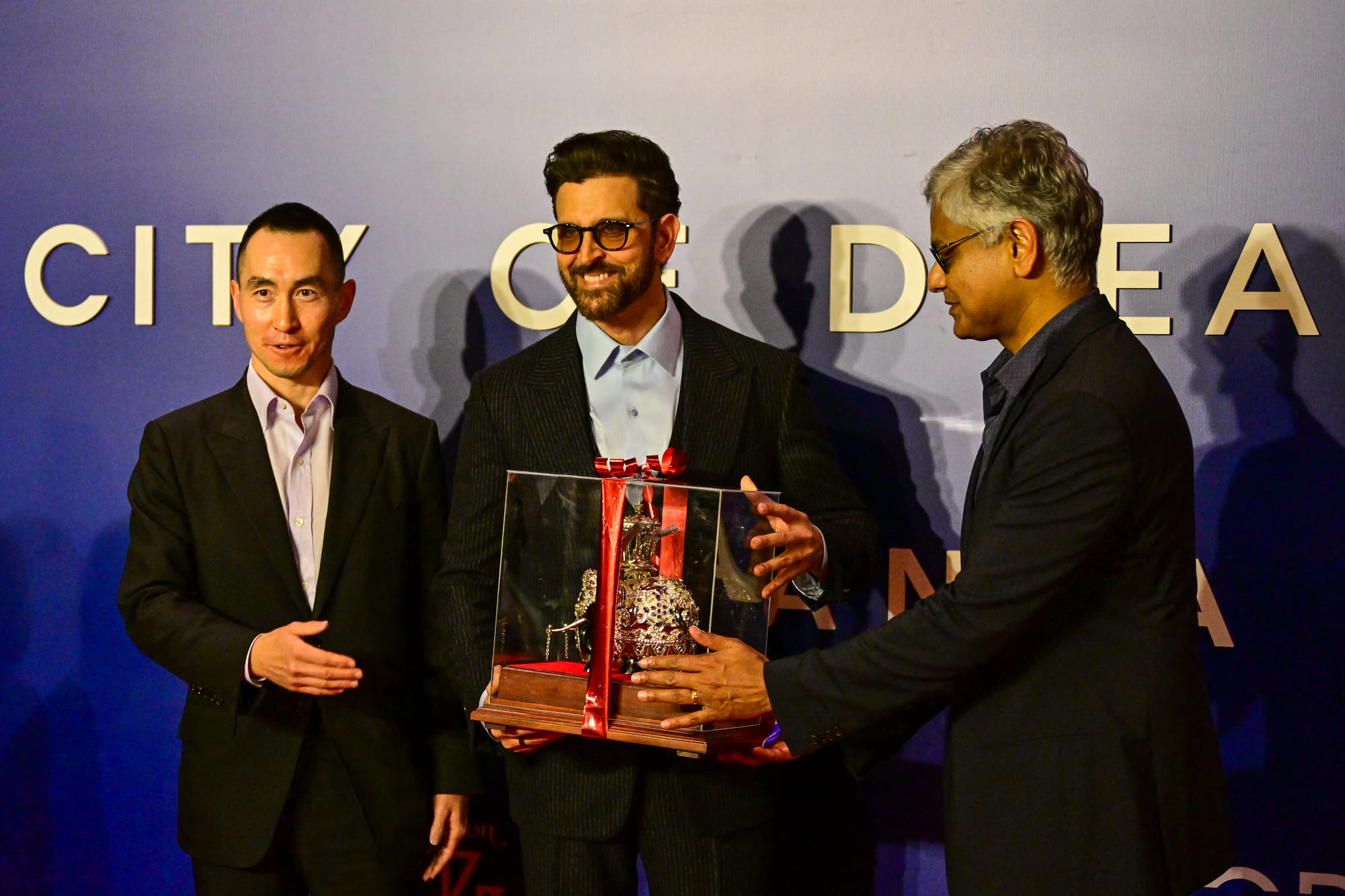 Hrithik Roshan (C) receives a present from Chairman of John Keells Holdings, Krishan Balendra (R) and CEO of Melco Resorts & Entertainment, Lawrence Ho (L) during opening ceremony of ‘City of Dreams’ in Colombo on August 2, 2025.