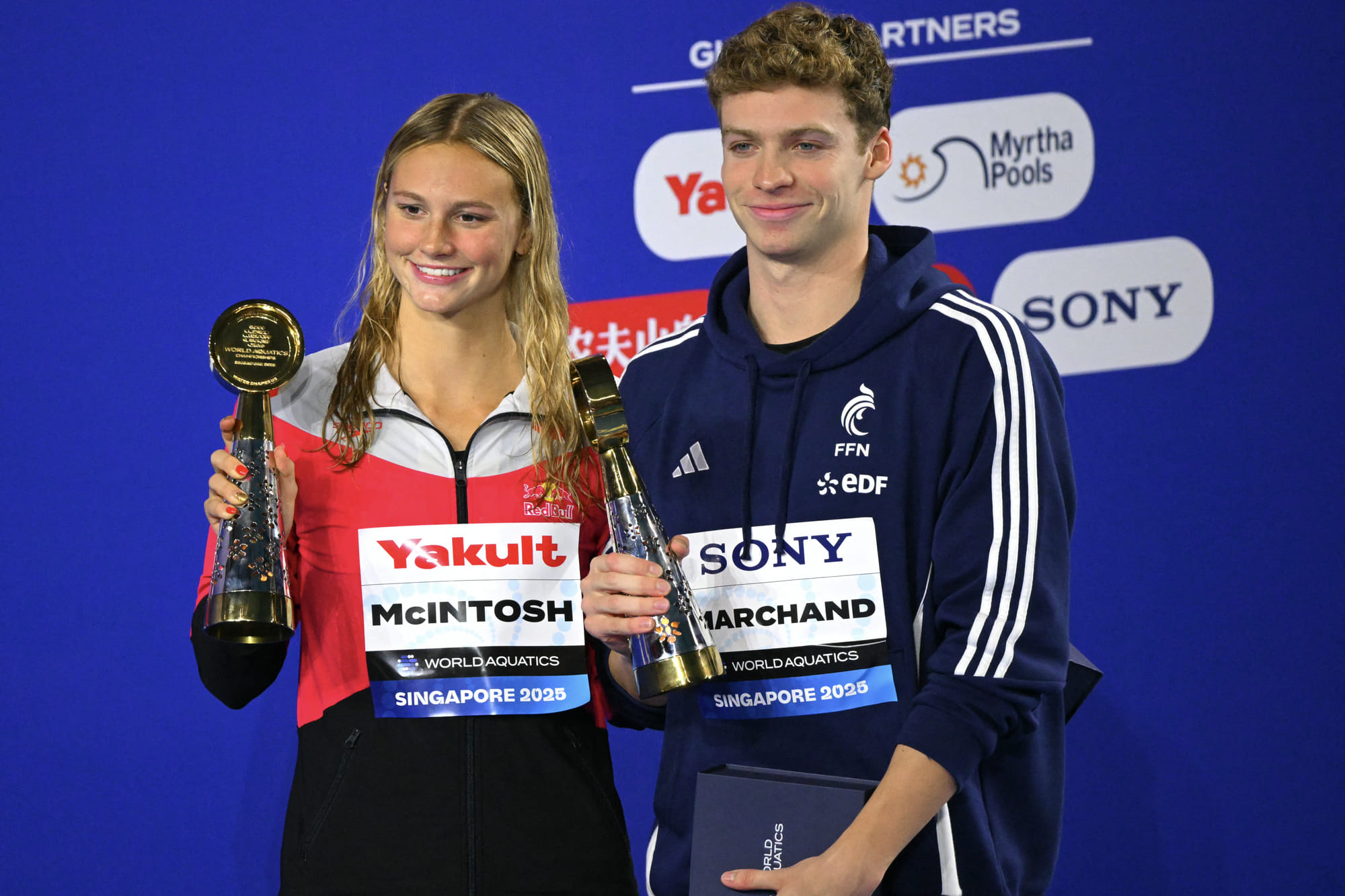 Canada's swimmer Summer Mcintosh (L) and France's swimmer Leon Marchand (R) pose with their best women's and men's championship swimmers at the end of the swimming event during the 2025 World Aquatics Championships in Singapore on August 3, 2025.