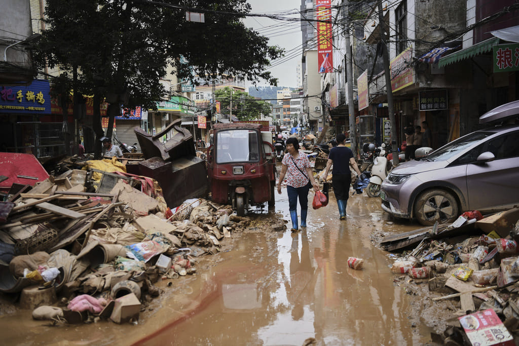 Residents wade through debris along a flood-hit street after waters from a river overwhelmed towns following days of heavy rain, in Huaiji County, south China's Guangdong Province.