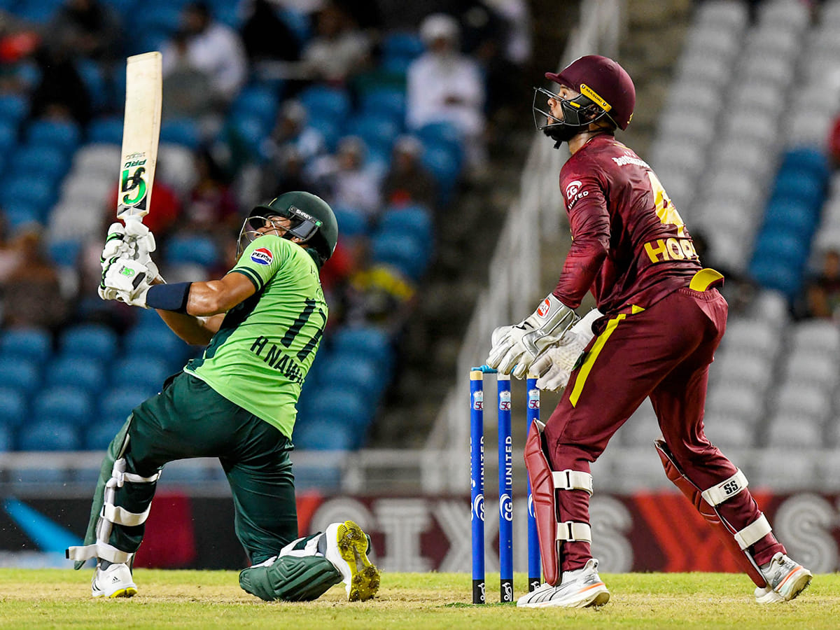 Hasan Nawaz (L) of Pakistan hits 6 as Shai Hope (R) of West Indies watches during the first ODI at Brian Lara Cricket Academy in Tarouba, San Fernando, Trinidad and Tobago on August 8, 2025.