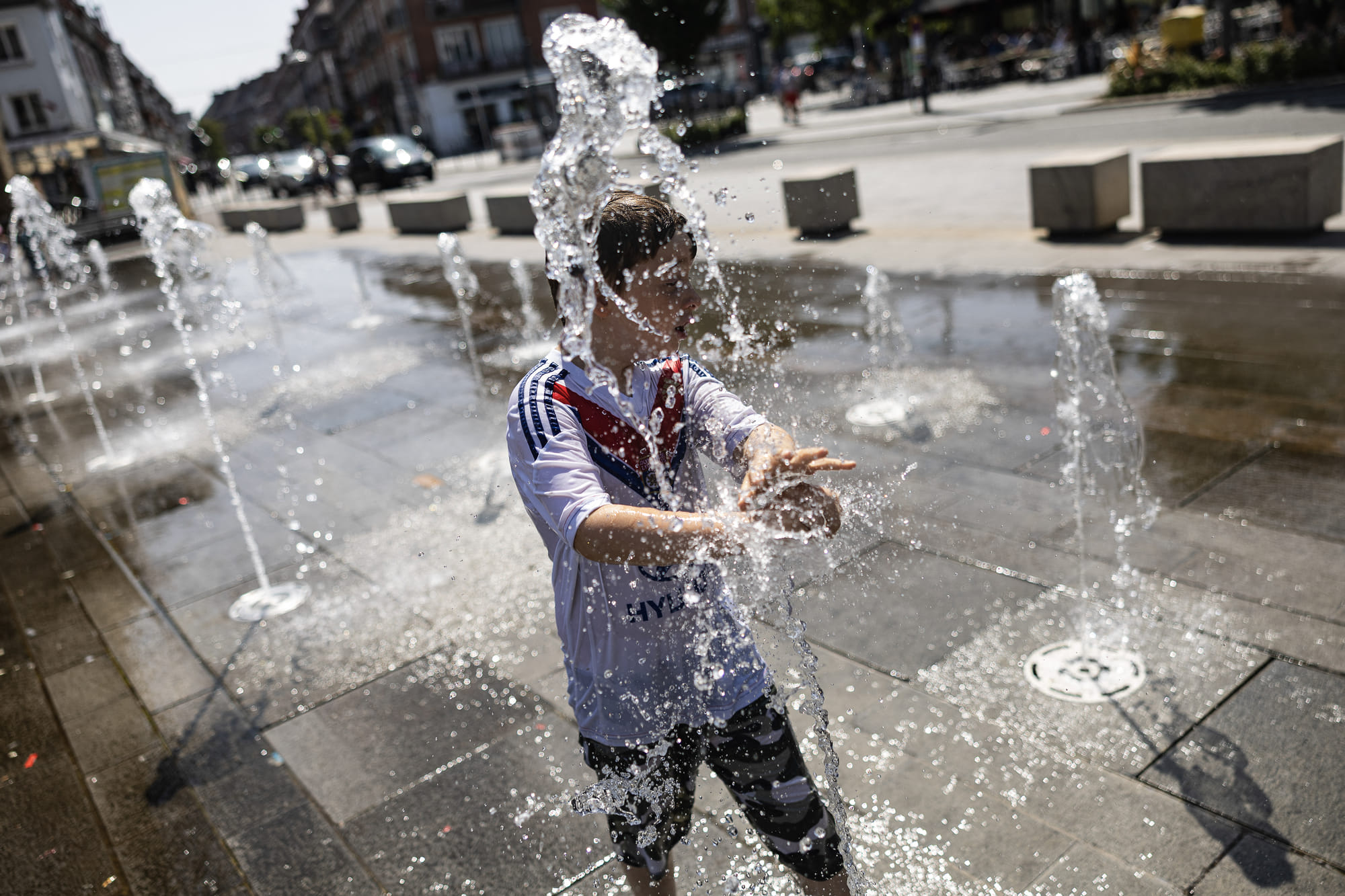A child cools off himself at a fountain in Place d'Armes in Calais, northern France on August 12, 2025, amid a heatwave in Europe. A heatwave swept through parts of Europe, breaking temperature records at weather stations in southern France and sparking wildfire risks while Bulgaria battled nearly 200 blazes.