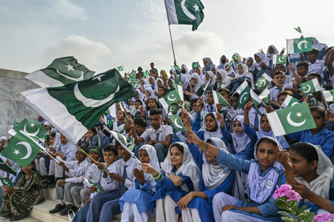 Students wave Pakistan's national flags during Independence Day celebrations at the mausoleum of the country's founding father, Muhammad Ali Jinnah, in Karachi on August 14, 2025.