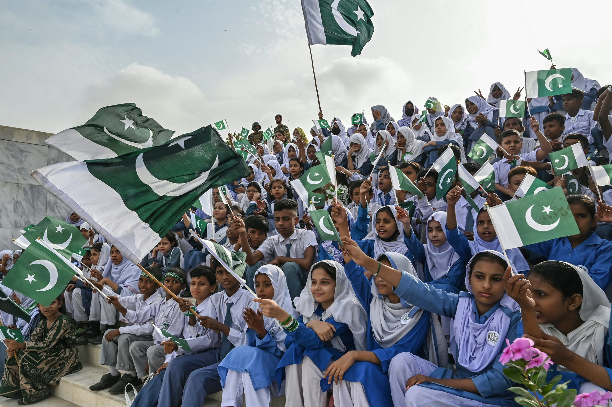 Students wave Pakistan's national flags during Independence Day celebrations at the mausoleum of the country's founding father, Muhammad Ali Jinnah, in Karachi on August 14, 2025.