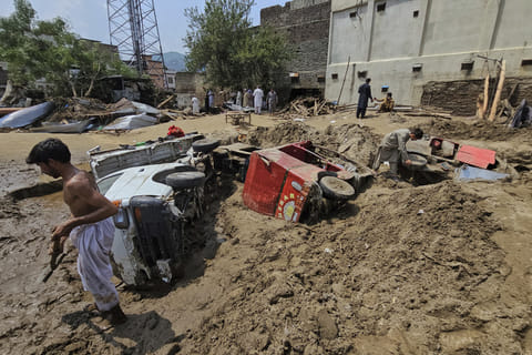 Local residents remove mud to recover vehicles from debris after Friday's flash flooding, in Mingora, the main town of Swat Valley, in Pakistan's northwest on August 16, 2025.  
