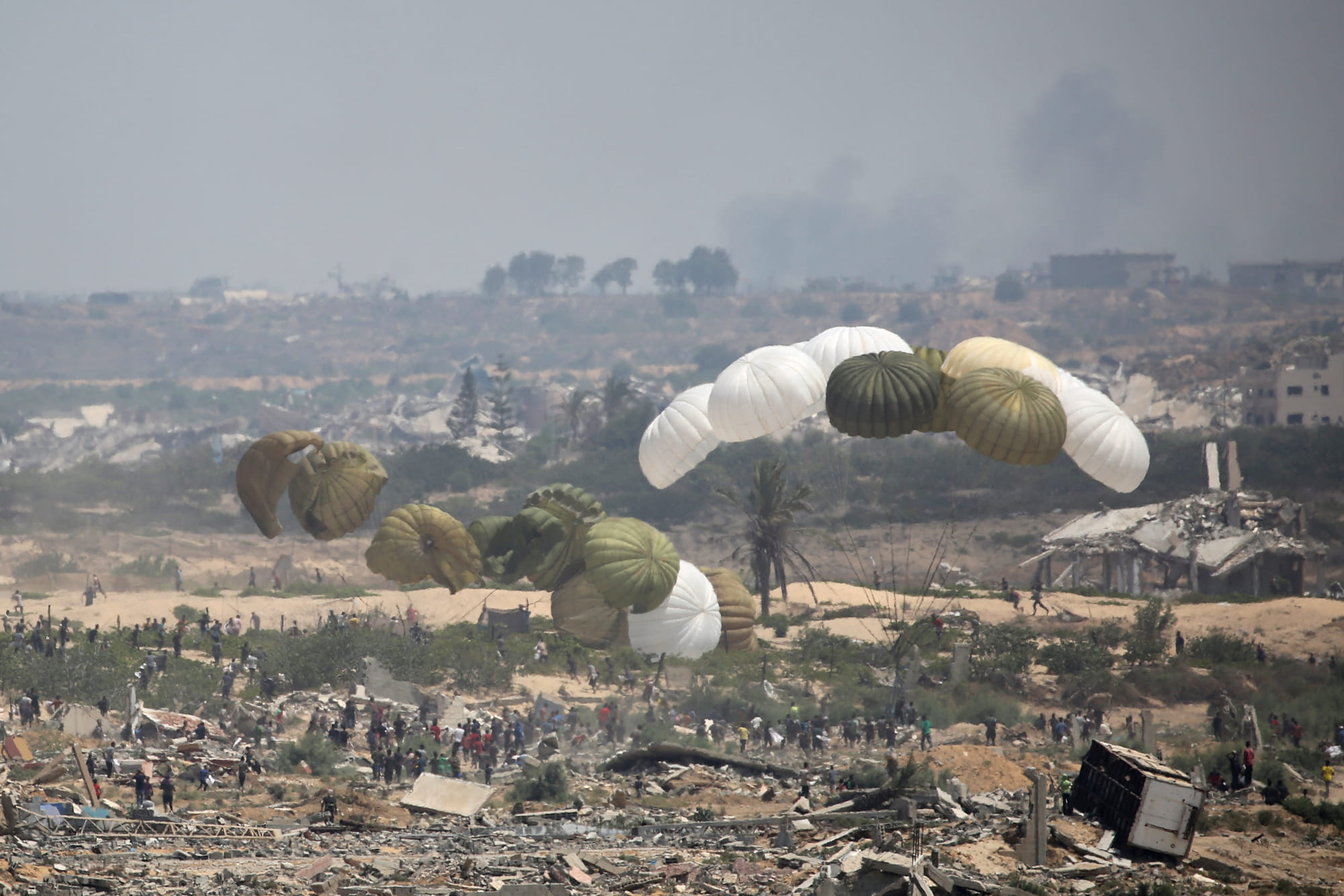 Aid pallets are parachuted after being dropped from a military plane over Nuseirat in the central Gaza Strip during an airdrop mission above the Israel-besieged Palestinian territory on August 18, 2025.