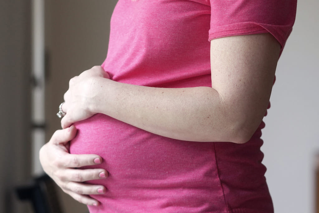 A pregnant woman stands for a portrait in Dallas, May 18, 2023. Photo used for illustrative purposes.