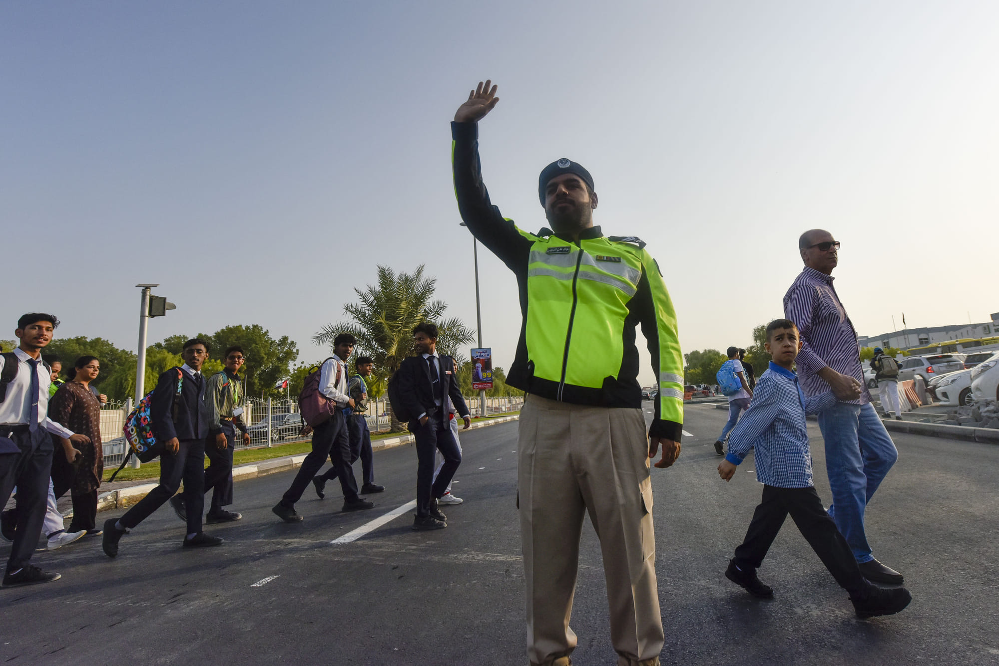Sharjah police officers help students and parents cross the road on the first day of school after summer vacation at Muweilah school area in Sharjah.