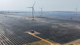 An aerial photograph taken on October 15, 2024, shows wind turbines and solar panels installed at the Adani Green Renewable Energy Plant in Khavda, in India's Gujarat state.