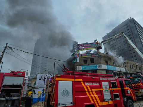 Firefighters try to extinguish a fire following an explosion at a fireworks storage facility, in Karachi, on Thursday, August 21, 2025. 