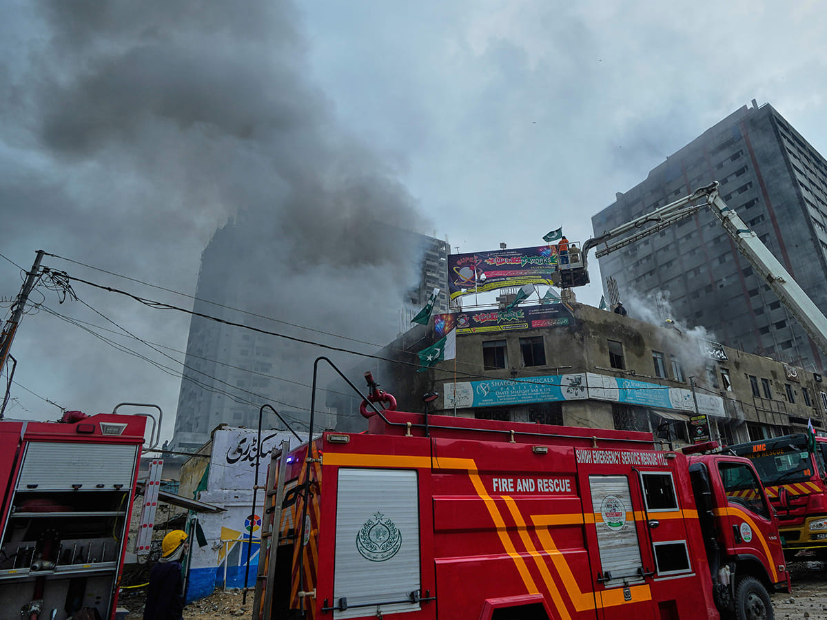 Firefighters try to extinguish a fire following an explosion at a fireworks storage facility, in Karachi, on Thursday, August 21, 2025. 